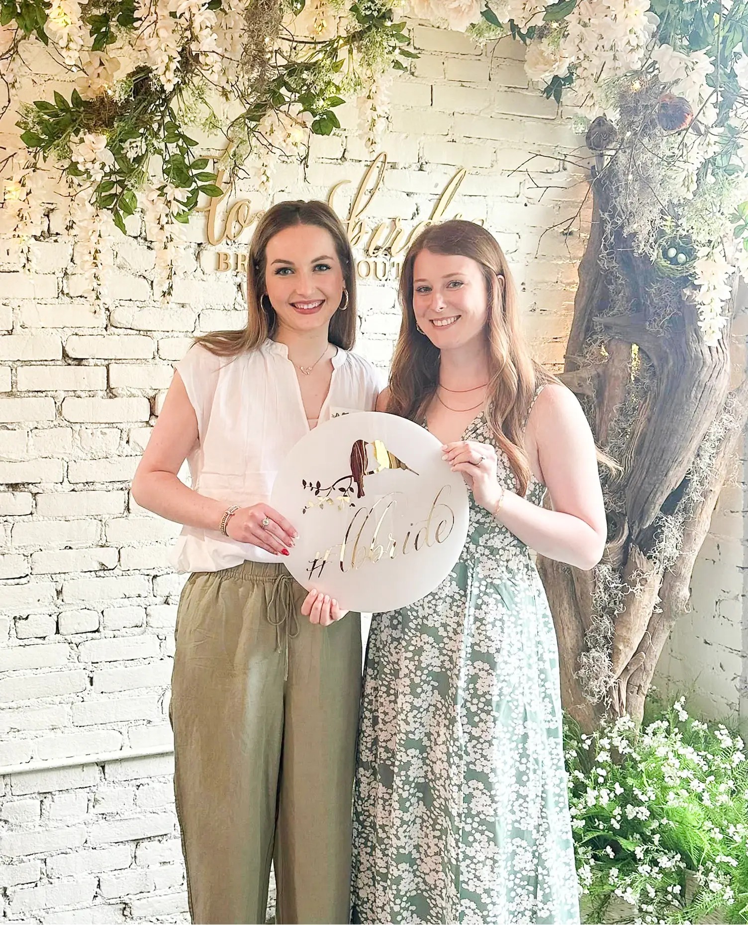 Models holding the sign with the store logo